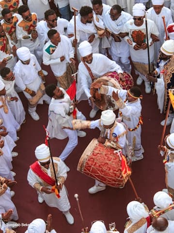 A procession of people in white ceremonial dress