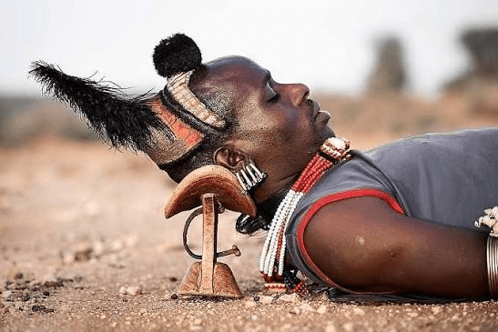 A man resting on a traditional headrest